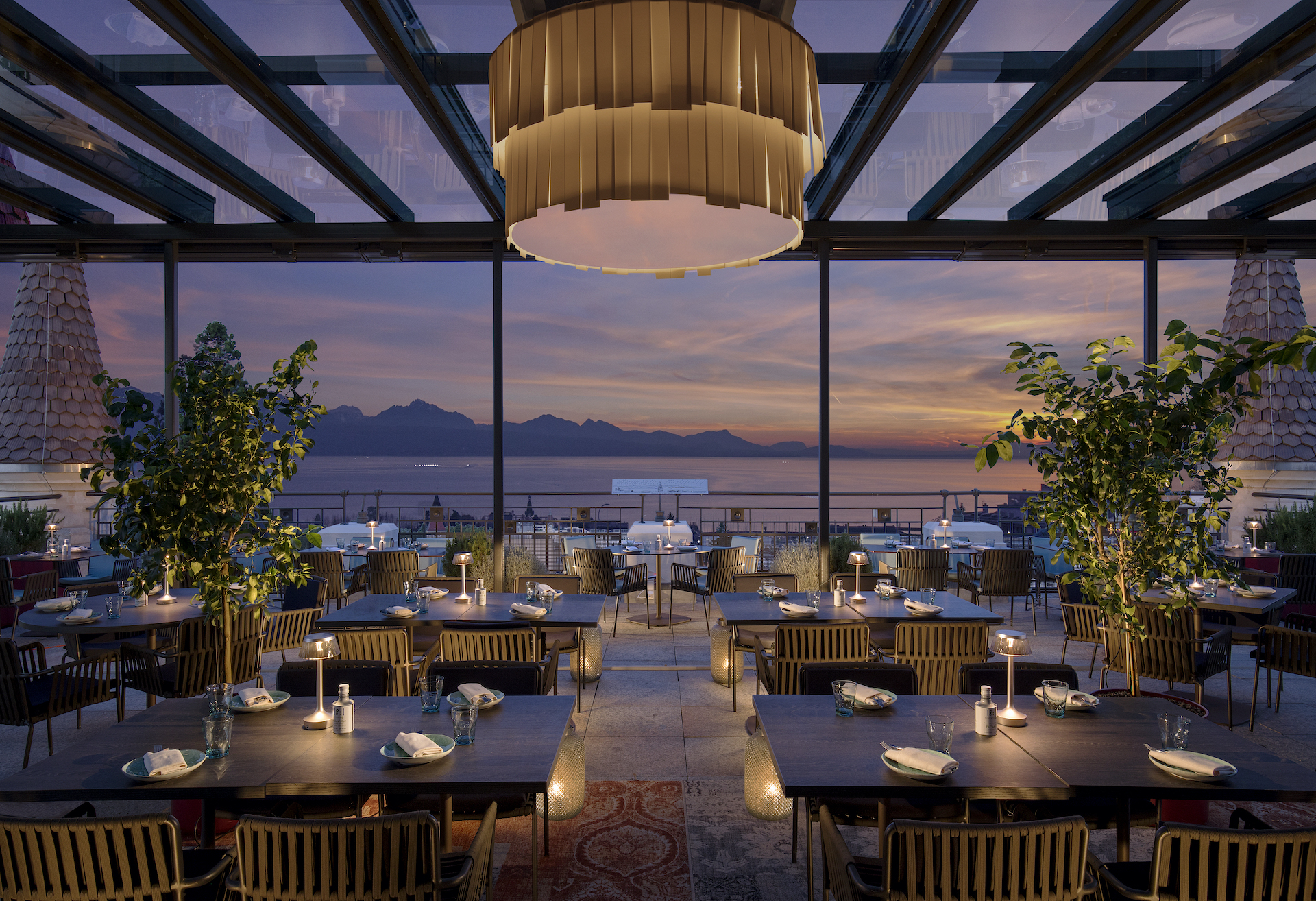 Panoramic sunset view from a stylish rooftop restaurant, evoking a serene, elegant dining experience ideal for hospitality businesses.