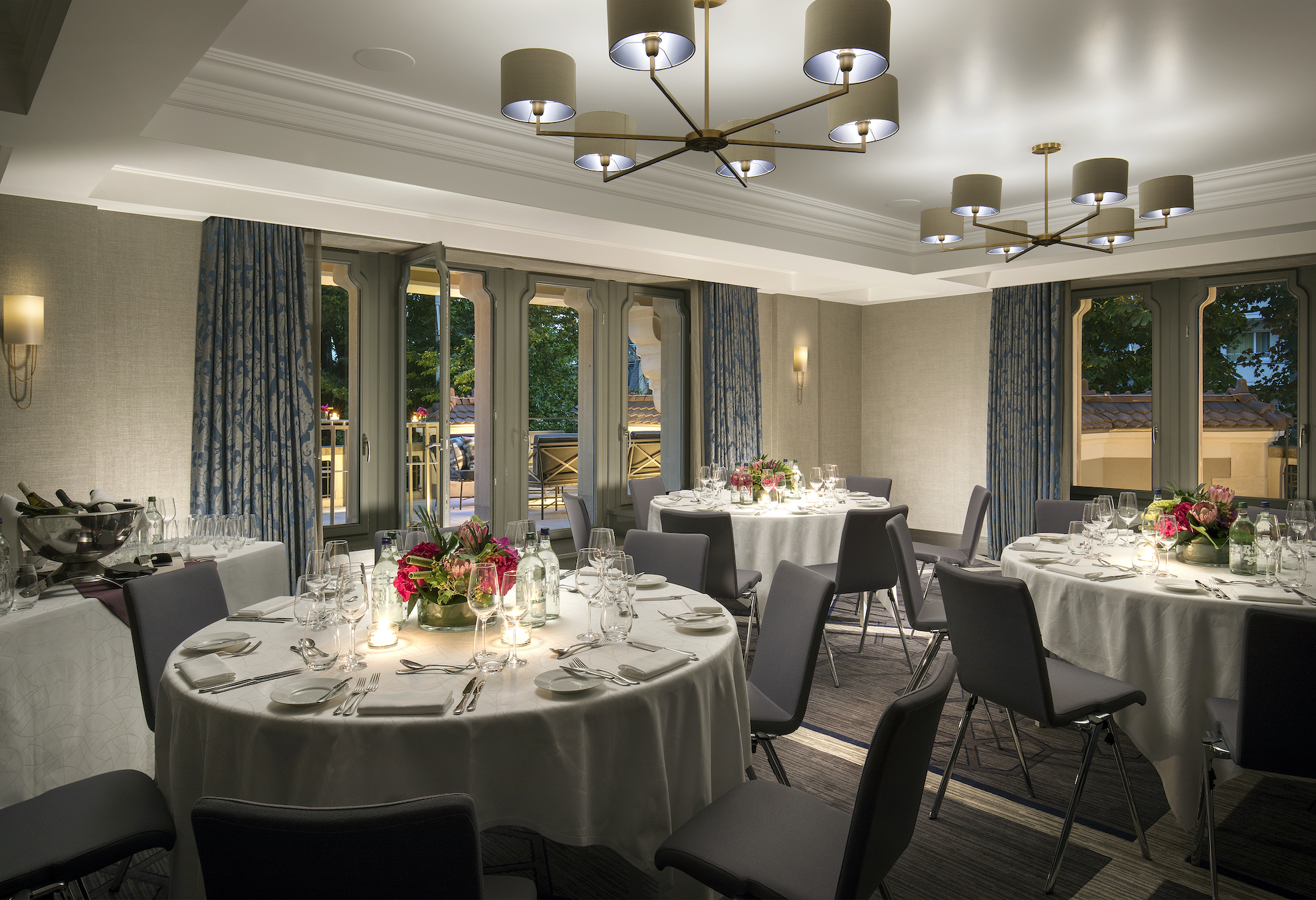 Elegant dining setup with grey and blue tones and floral centerpieces, exuding a sophisticated and welcoming atmosphere for event hosting.