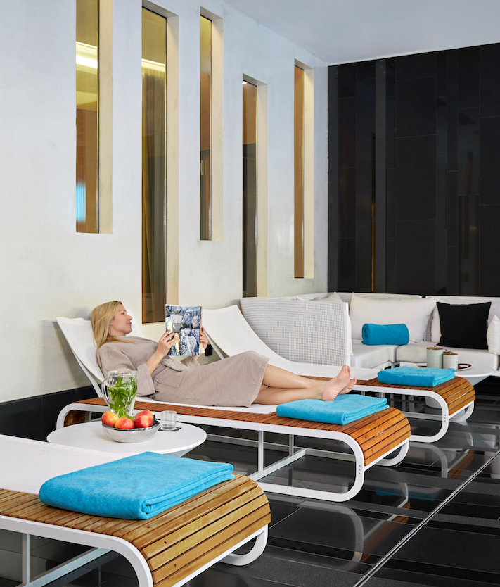 Sleek spa-like relaxation space with a serene palette and plush loungers, exuding tranquility and luxury, ideal for hospitality settings.