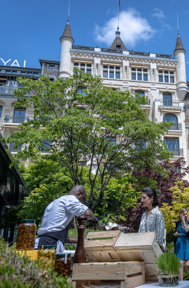 Outdoor food market scene with a vendor serving a customer in front of a historic building, presenting an inviting and bustling culinary experience.