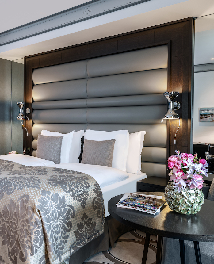 Elegant hotel room with a plush king-sized bed and soft-toned lighting, offering a serene and luxurious ambiance ideal for travelers.