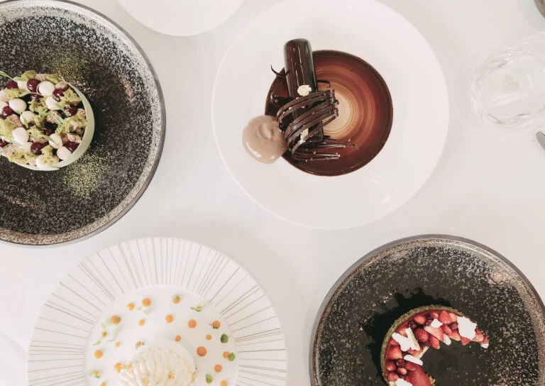 Elegant dessert plates with artistic plating, using vibrant colors, inviting a taste of refined culinary arts for food enthusiasts.