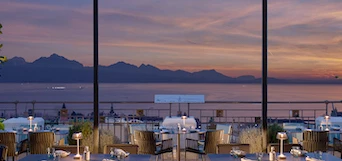 Elegant dining area with a sunset view over mountains, paired with a warm, inviting ambiance ideal for fine dining establishments.