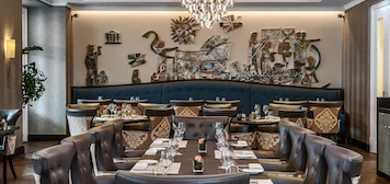 Elegant dining room with ornate chandelier and plush chairs, exuding sophistication for fine dining experiences.