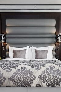 Monochrome bedroom with a patterned bedspread and plush headboard, exuding a calm and elegant ambiance perfect for interior design enthusiasts.